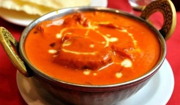 Authentic Butter Chicken in traditional copper bowl at Mother India Fremantle